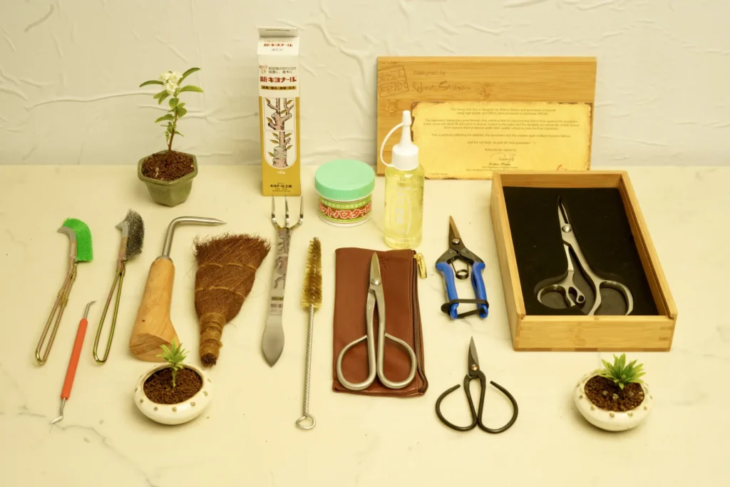 Selection of bonsai tools including scissors, pruners, brushes, root rakes and oils