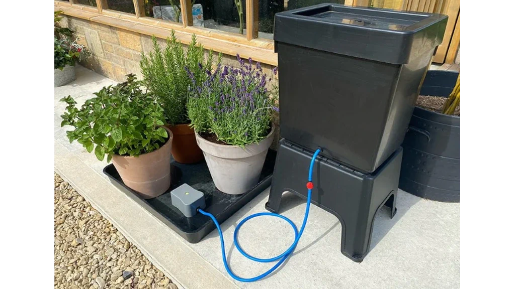 Outdoor Easy 2 Go watering setup, with piping, membrane and plant pots visible